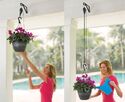 Man lifting plant into hanging place after tending to it